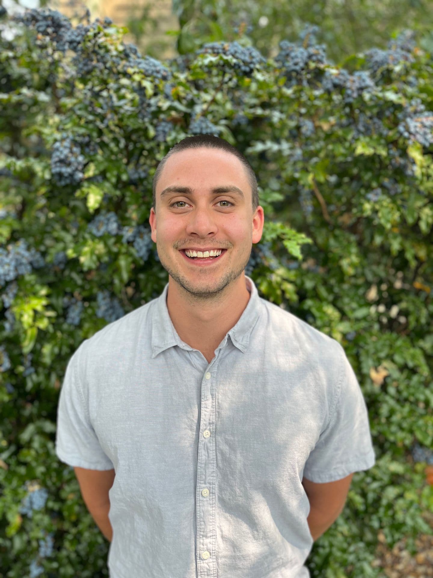 Erik Flaten, standing in front of an oregon-grape hedge